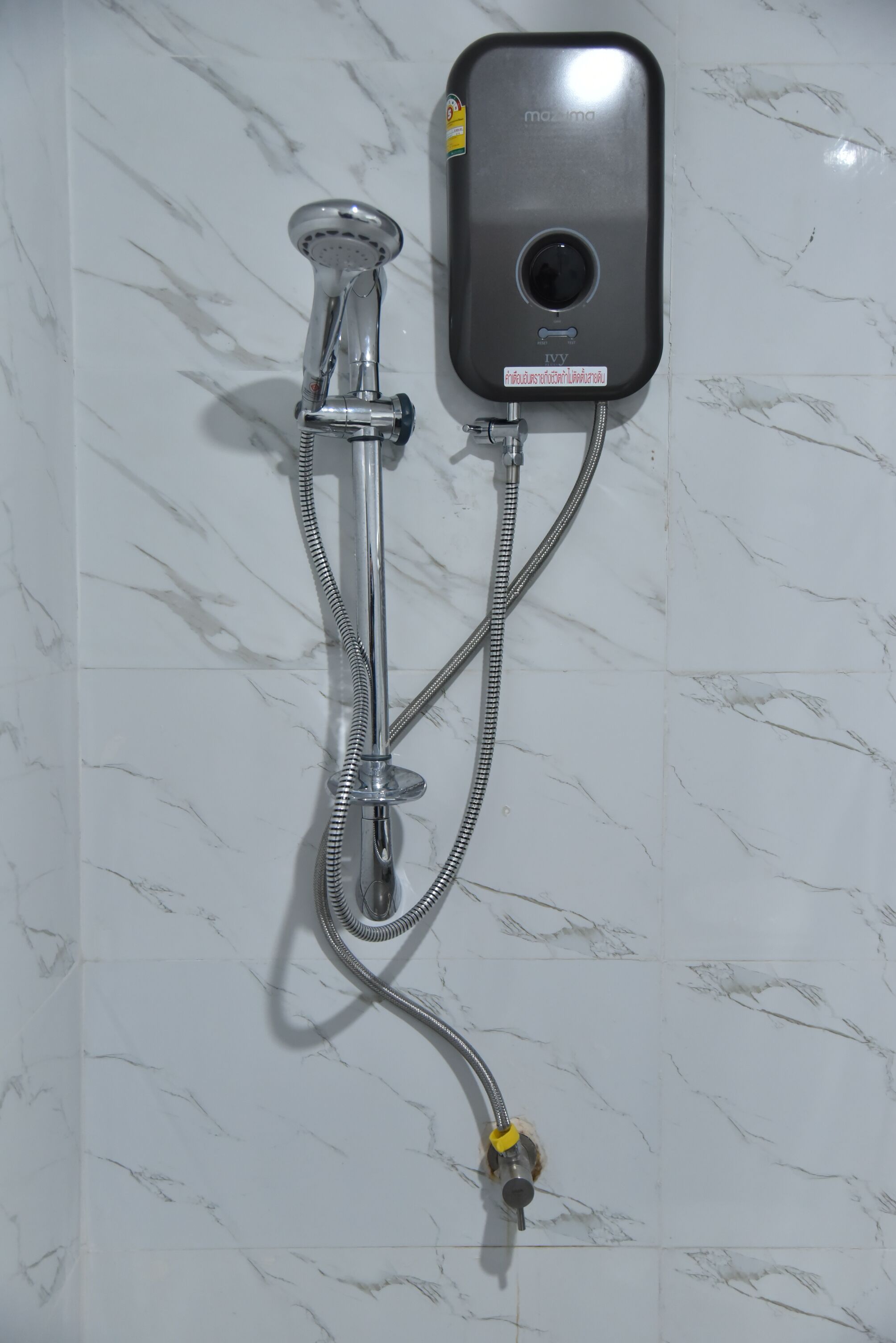 A wall-mounted shower with a handheld showerhead and a control panel.