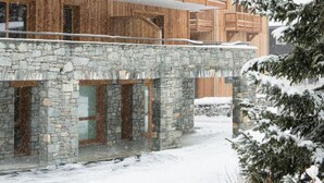 A multi-story wooden building with balconies and a stone base. - 100m from ski lifts, fitness, swimming pool, sauna, hammam, balcony, tv, 40m², Tignes (Tignes)