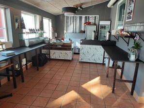 Una cocina con piso de baldosas, un mostrador con un florero y una ventana con vista al exterior.