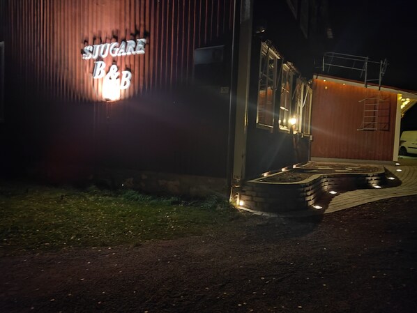 Un edificio con un letrero que dice "SUGAR B&B" durante la noche.