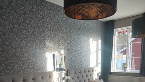 A bedroom with two beds, a large mirror, and a hanging light fixture. - Sjugare Bed & Breakfast (Leksand)