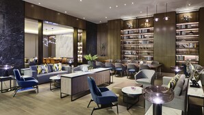 A modern hotel lobby with a bar area, seating arrangements, and a large bookshelf. - Crowne Plaza Wuhan Development Zone by IHG (Wuhan)
