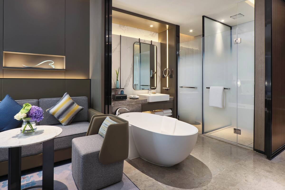 A modern bathroom with a freestanding bathtub, a glass-enclosed shower, and a vanity with a mirror.