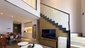 Un intérieur moderne comprenant un coin repas, une cuisine et un escalier.