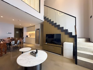 A modern interior with a dining area, kitchen, and a staircase. - Crowne Plaza Wuhan Development Zone by IHG (Wuhan)
