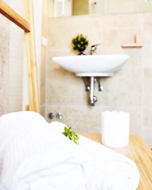 A bathroom with a wooden vanity, a white sink, and a small plant on the counter. - Fabrì 171 (Pescara)