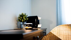 A small table with a coffee maker, a cup, and a plate with two muffins. - Fabrì 171 (Pescara)
