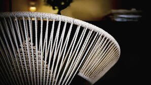 A close-up of a woven chair with a curved backrest. - Fabrì 171 (Pescara)