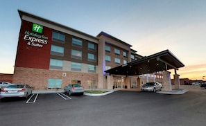 A Holiday Inn Express & Suites building with a covered entrance and a parking lot. - Holiday Inn Express & Suites Detroit North - Roseville by IHG (Roseville)