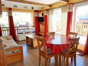 Relax in this inviting room with a sofa, round table, and large windows offering a view of the outdoors.