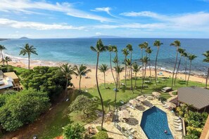 Um resort com piscina, praia e palmeiras.
