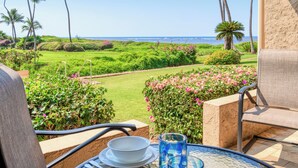 Ein Balkon mit Blick auf einen gepflegten Garten und das Meer.