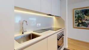 Eine moderne Küche mit integriertem Spülbecken, einem Edelstahlarmaturen und einem kompakten Backofen.