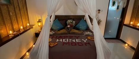 A bed with a canopy, a mirror, and a decorative mat with a floral design.