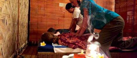A massage therapy session in a room with bamboo walls and a woven floor mat.