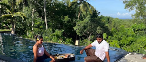 Zona de piscina con un arreglo floral y dos personas.