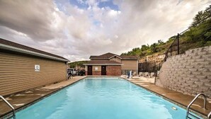 A swimming pool with a view of a building in the background. - Western Comfort (Branson)