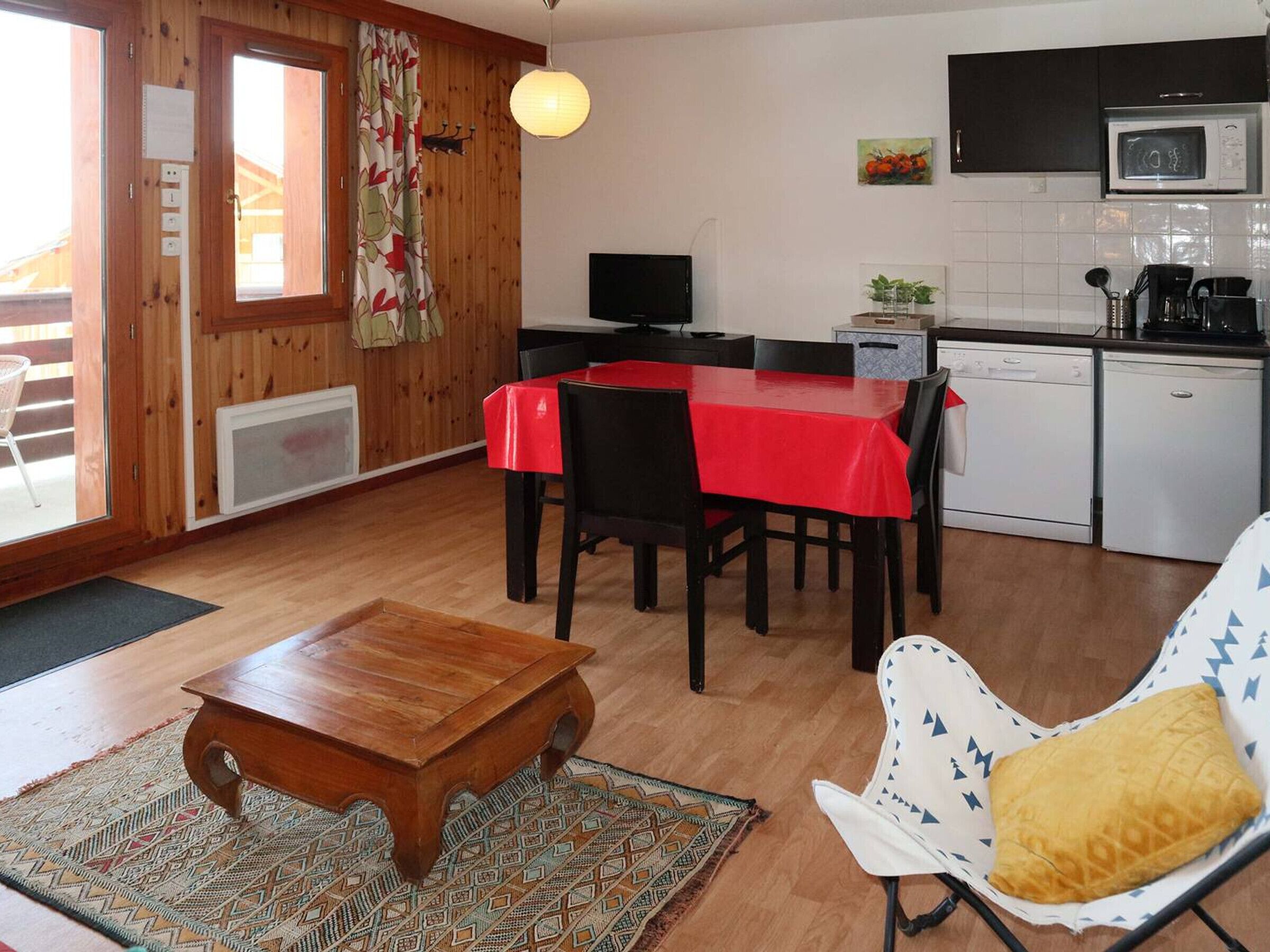 A compact kitchen with a dining area, a television, and a microwave.
