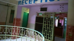 A reception area with a sign above the door, a green door, and a barred entrance. - Olympia Hotel (Nyahururu)