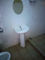 Ducha, artículos de tocador gratuitos, pantuflas, toallas