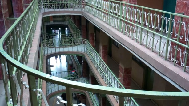 A multi-level atrium with green railings and a central staircase. - Olympia Hotel (Nyahururu)