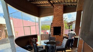 Un restaurant doté d’une cheminée en briques, d’une terrasse et offrant une vue sur les environs.