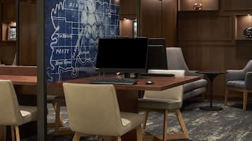 A conference room with a large map on the wall, a desk with a computer, and two chairs.