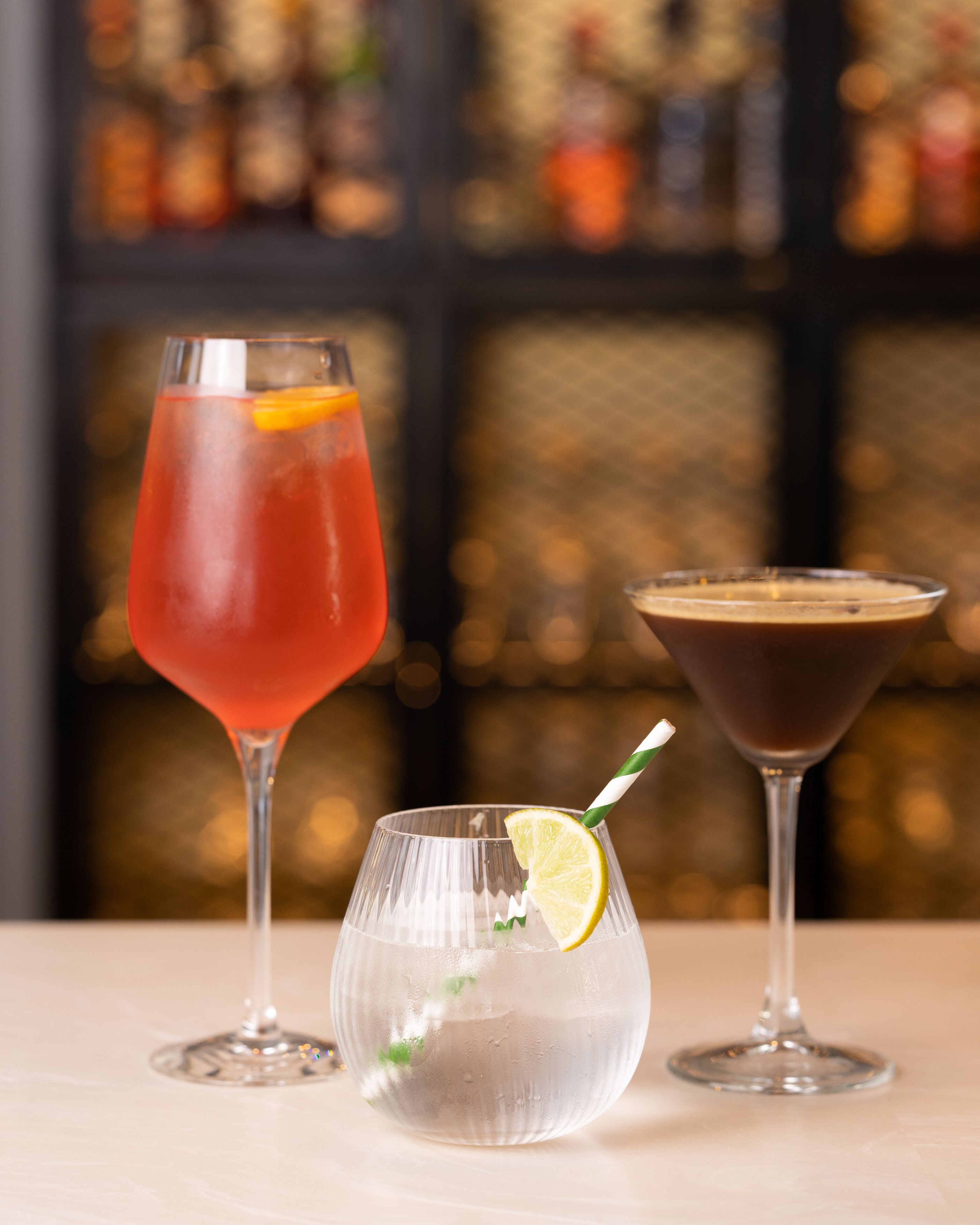 Three different cocktails in glasses on a table.