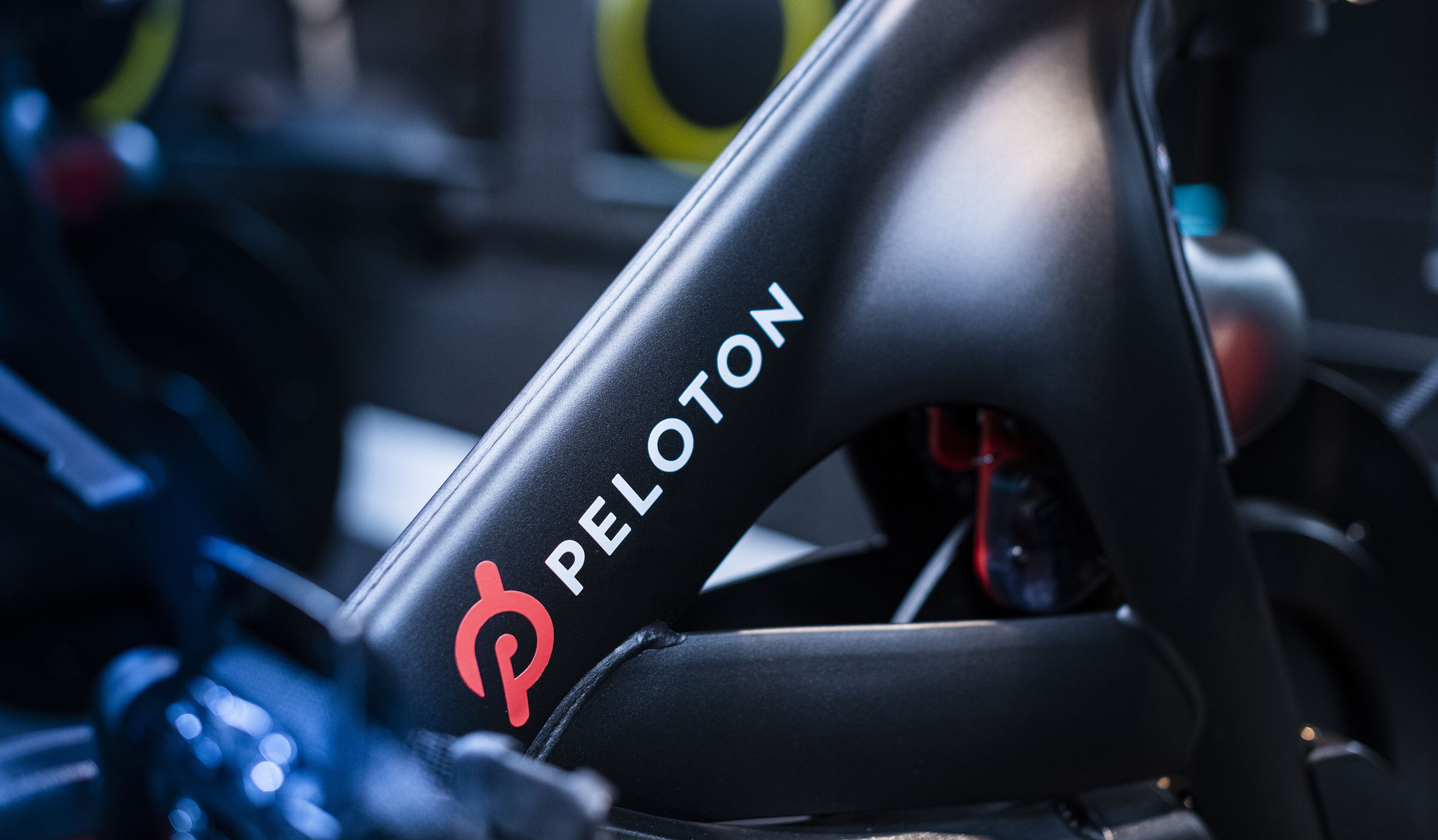 Gros plan sur un vélo d’exercice Peloton, avec le logo de la marque sur le guidon.