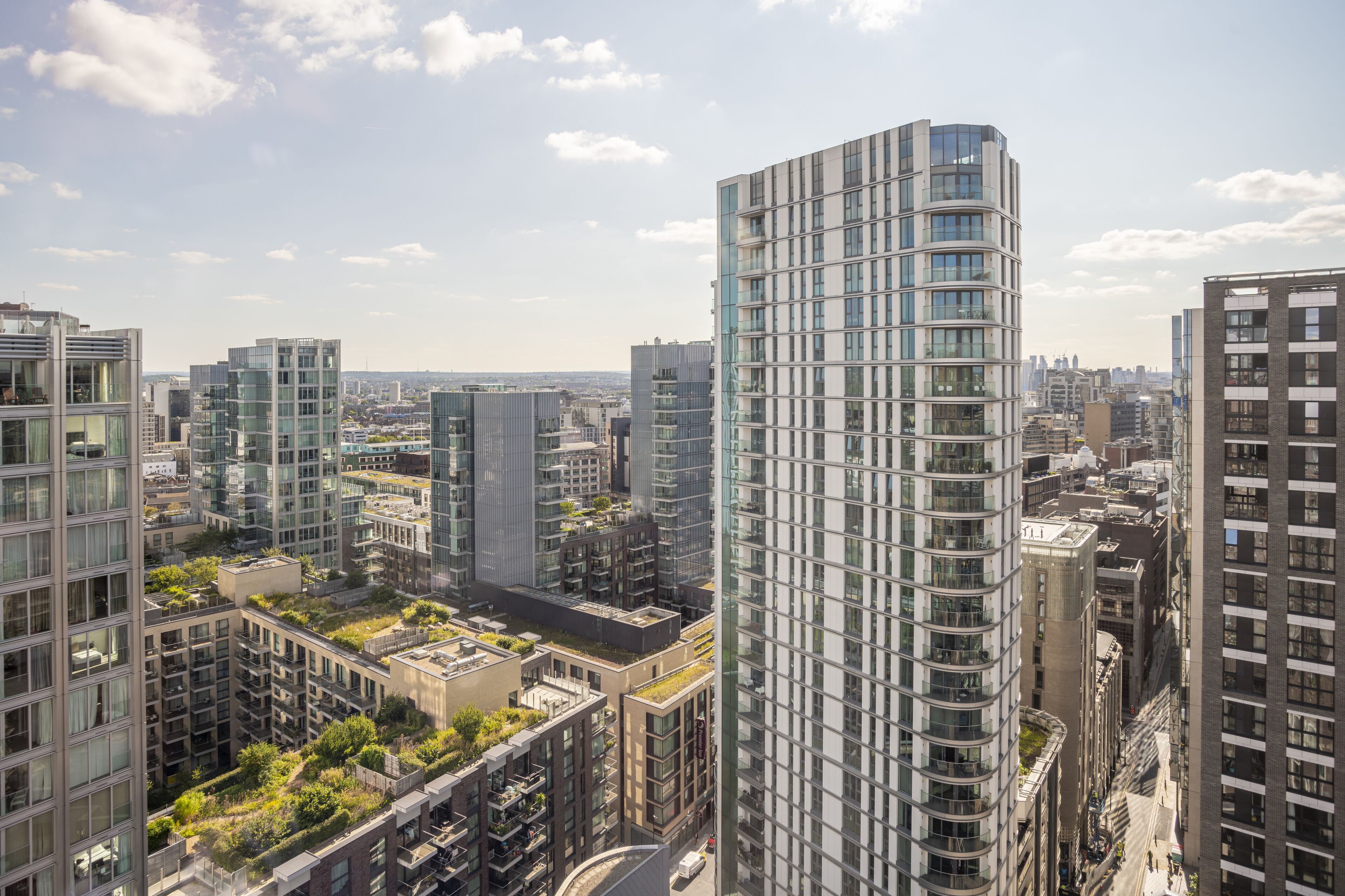 A high-rise building with a modern glass facade, surrounded by other high-rise buildings in an urban setting.