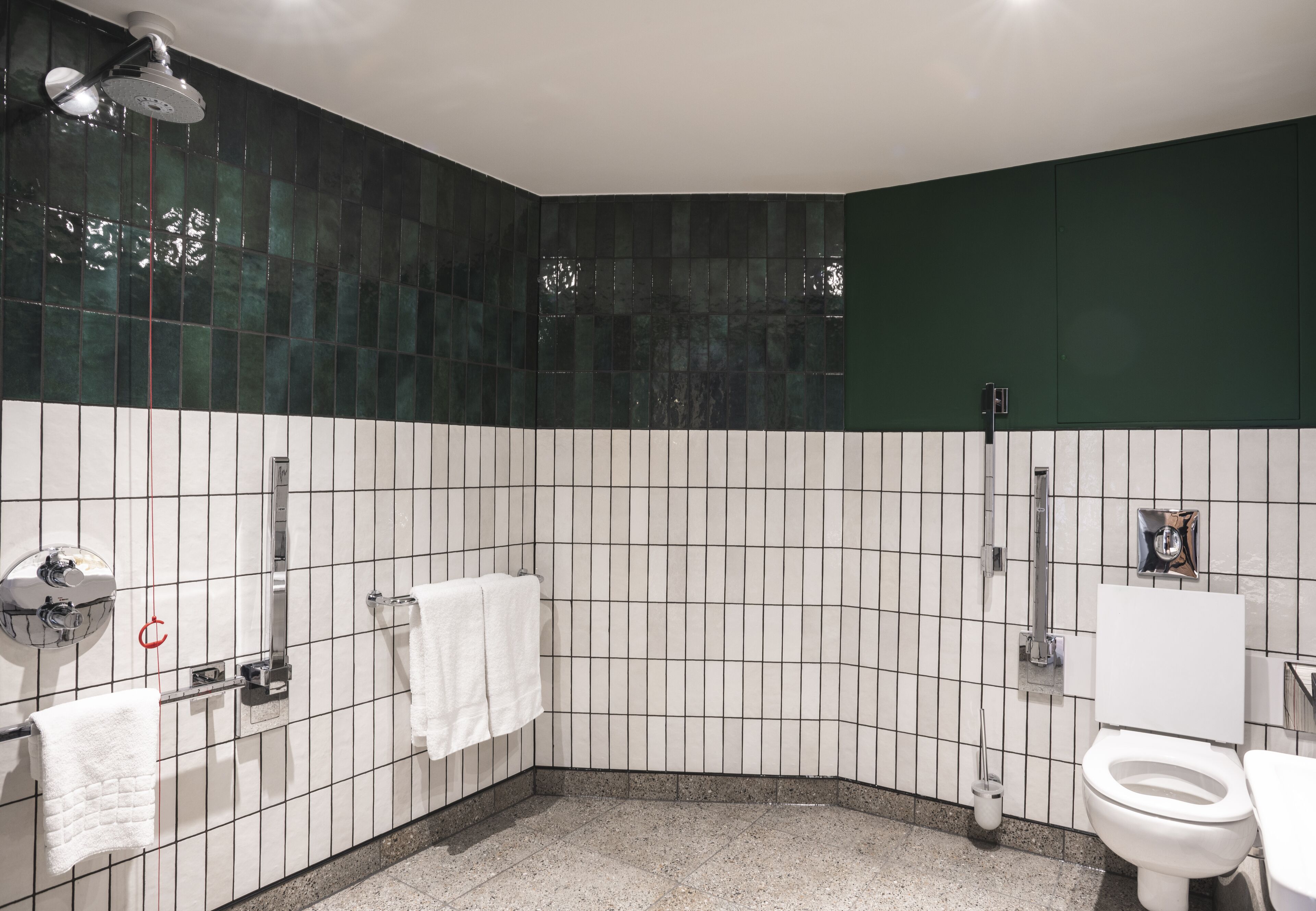 A bathroom with a shower, toilet, and sink.