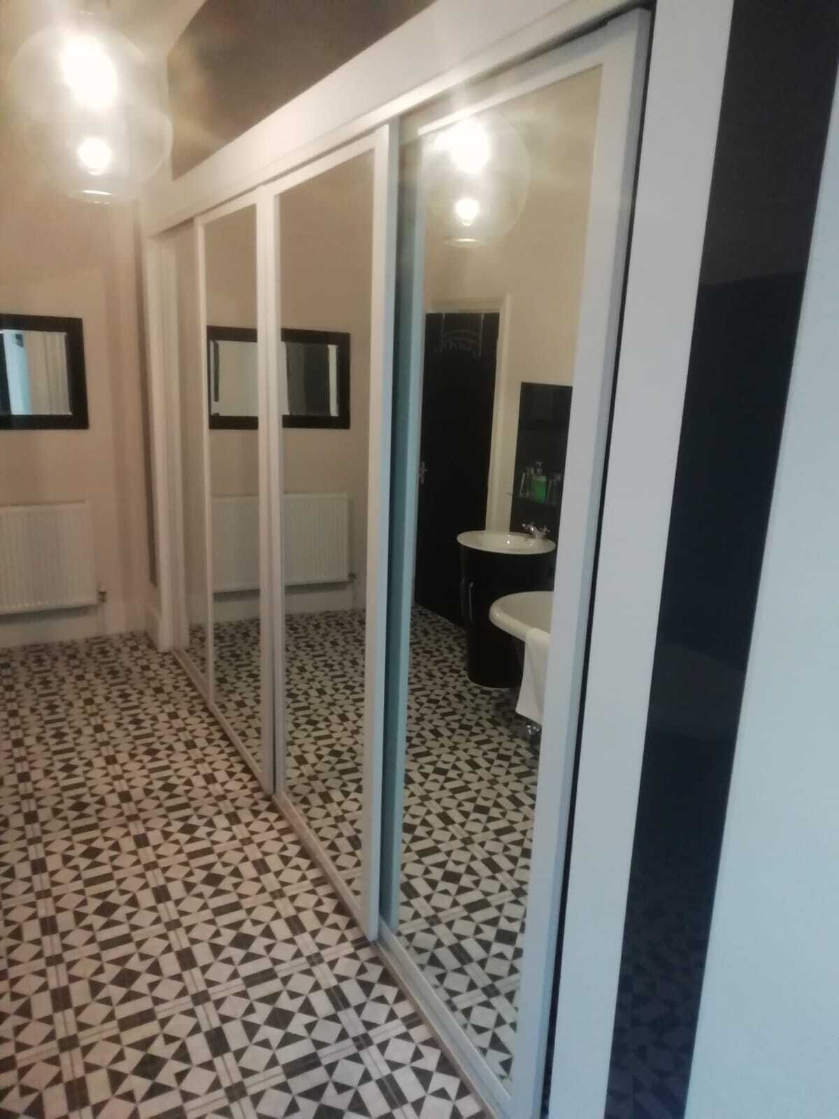 A bathroom with a checkered floor, a mirror, and a sink.