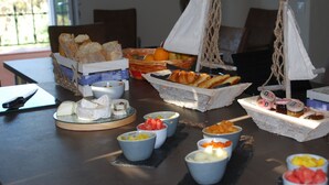 Un bufé de desayuno con diversos alimentos y un centro de mesa decorativo con un velero.
