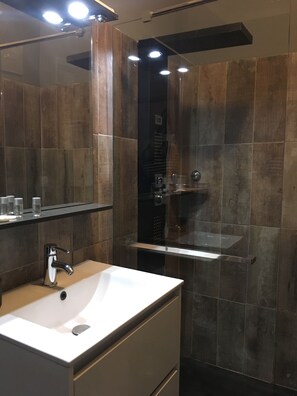 A modern bathroom with a white sink, a mirror, and a glass-enclosed shower. - La Calanque du Boucharel (Fréjus)