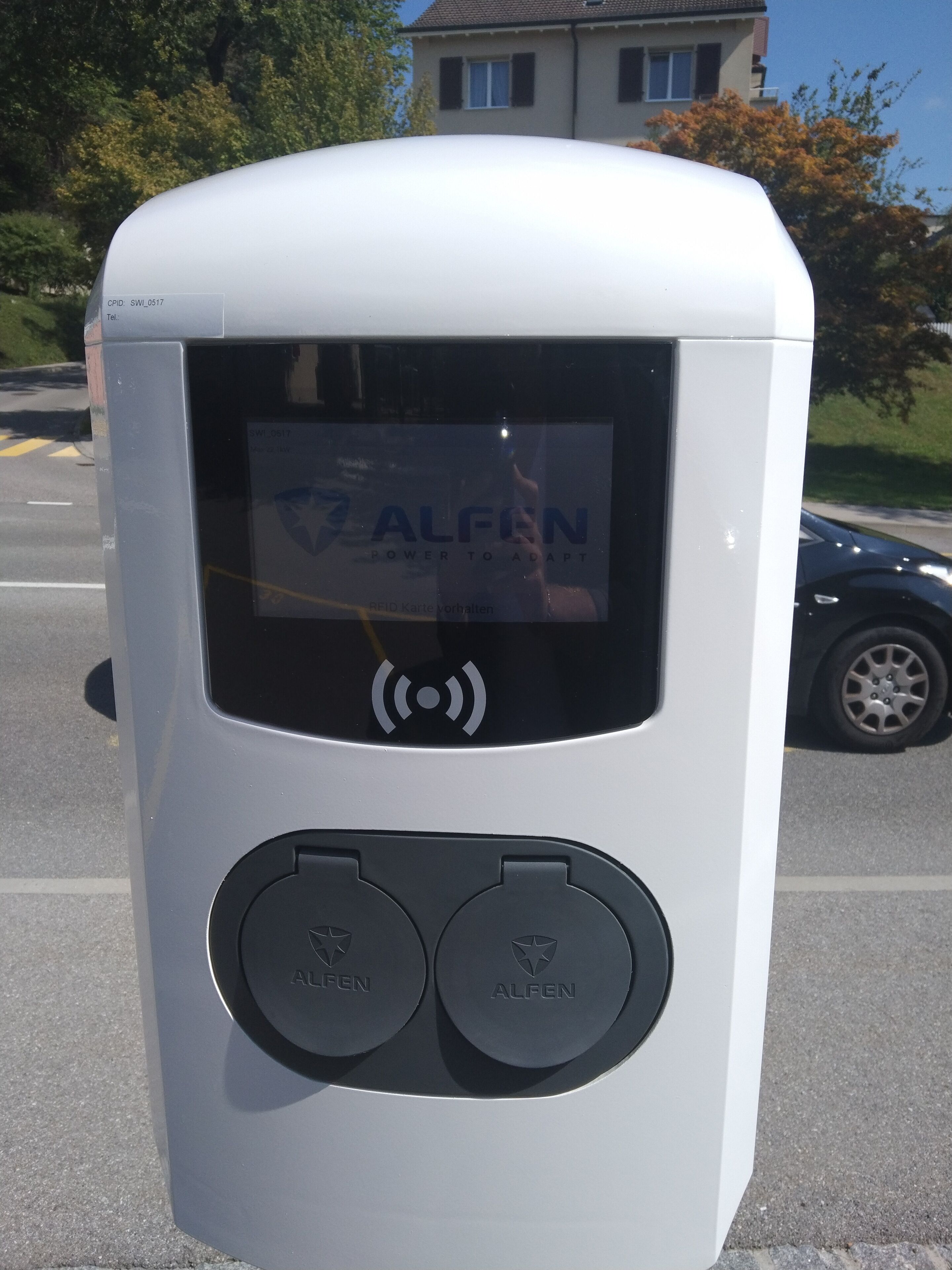 A white parking meter with a digital display and two buttons labeled "ALFEN".