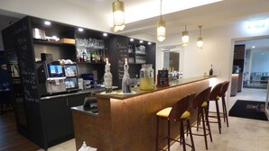 A bar area with a counter, stools, and a menu board. - Hotel La Belle Croix (Romont)