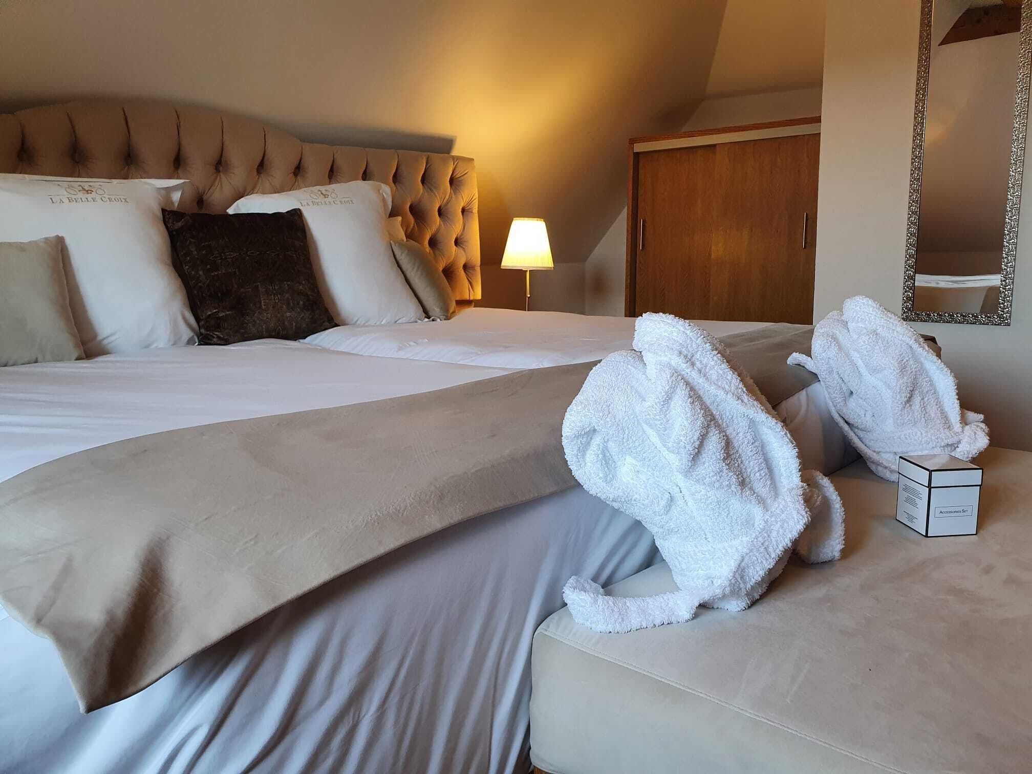 Une chambre d’hôtel avec un grand lit, une armoire en bois et un miroir au mur.