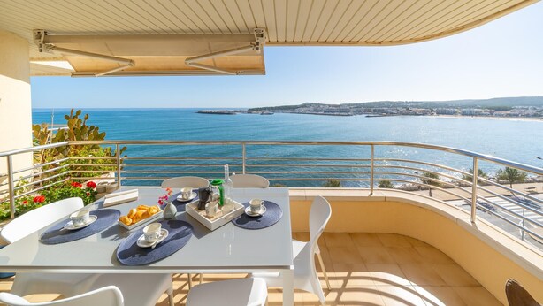 A balcony with a table set for breakfast, overlooking a coastal view. - Georgina: Apartment with sea view and community pool (L'Escala)