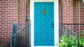 A blue door with the number 2419, a brick wall, and a small mailbox. - Cozy Tudor Bungalow in Waco (Waco)
