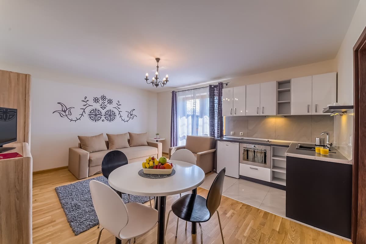 A modern apartment with a dining area, kitchen, and living space.