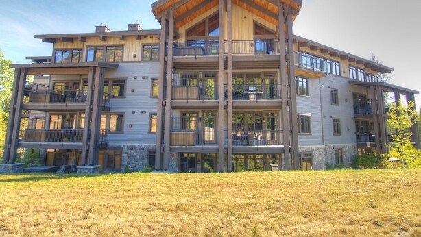 Un edificio de varios pisos con terraza de madera y balcones.