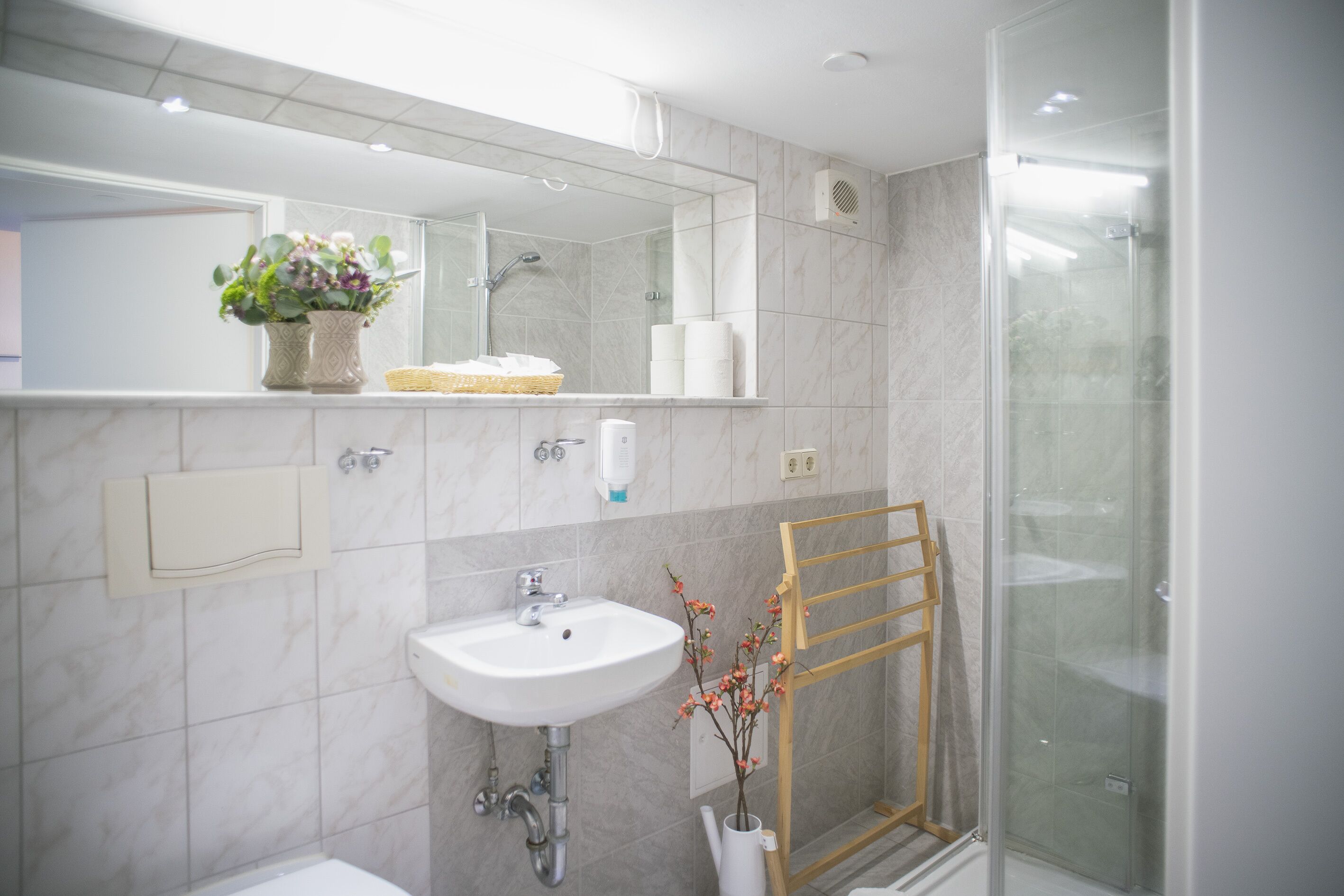 Une salle de bain moderne avec un lavabo, un miroir et une douche.