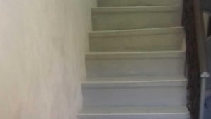 A staircase with a plain wall on one side and a door at the bottom. - B&B Gerace (Badolato)