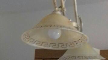 Een plafondlamp met een witte kap en zichtbare lamp.