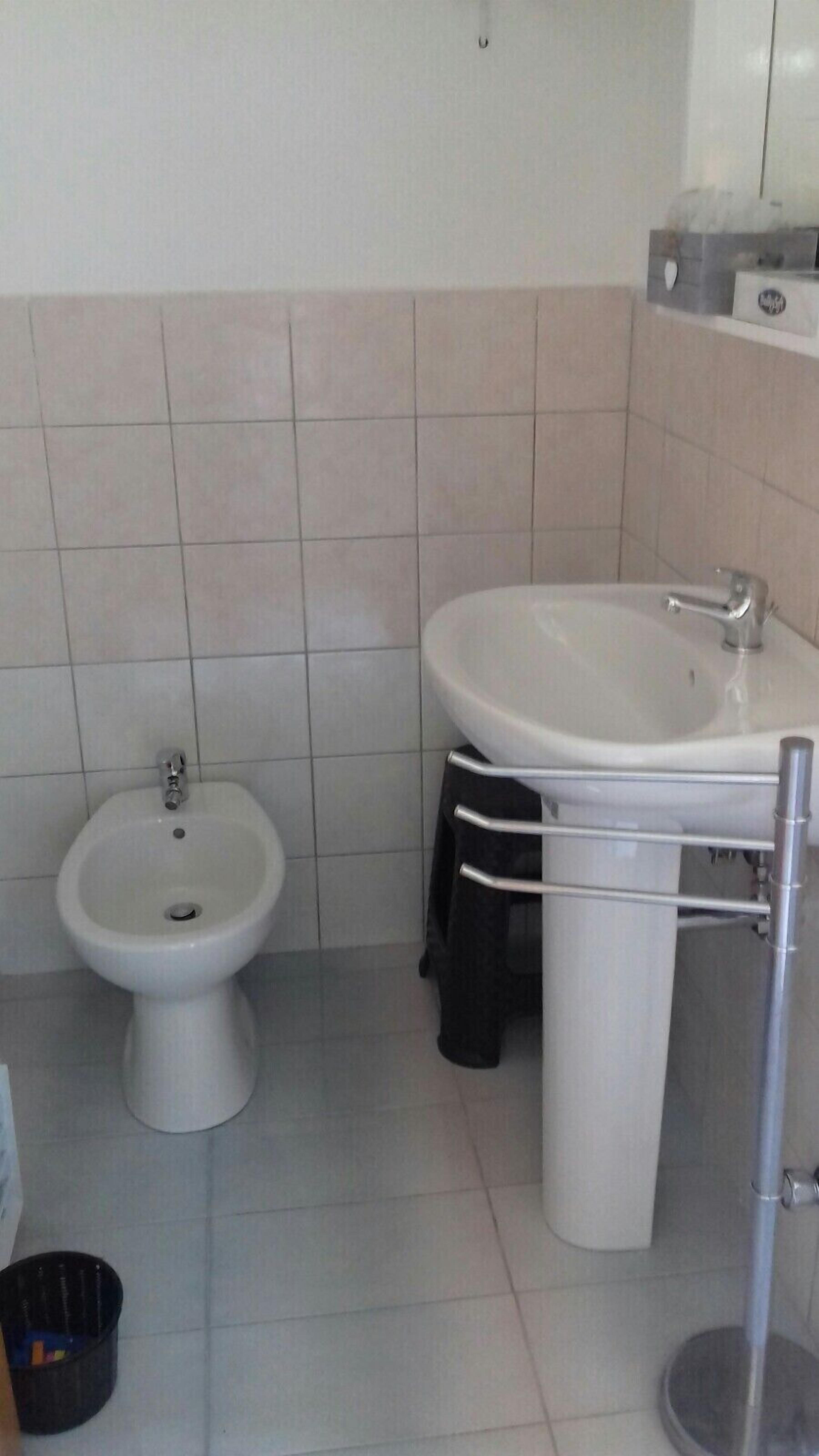 Un bagno con bidet, lavandino e water.