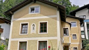 A two-story building with a textured facade, multiple windows, and a small porch area with a bench. - Wonderful private villa for 10 guests with WIFI, TV and terrace (Zell Am See)