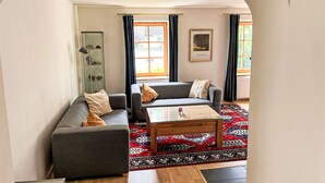 A living room with a sofa, a coffee table, and a patterned rug. - Wonderful private villa for 10 guests with WIFI, TV and terrace (Zell Am See)