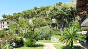 Un jardín bien cuidado con un camino de piedra que lleva a un edificio.