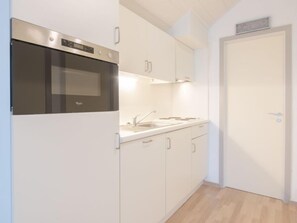 Enjoy cooking in this well-equipped kitchen with a sink, stainless steel oven, and range hood.
