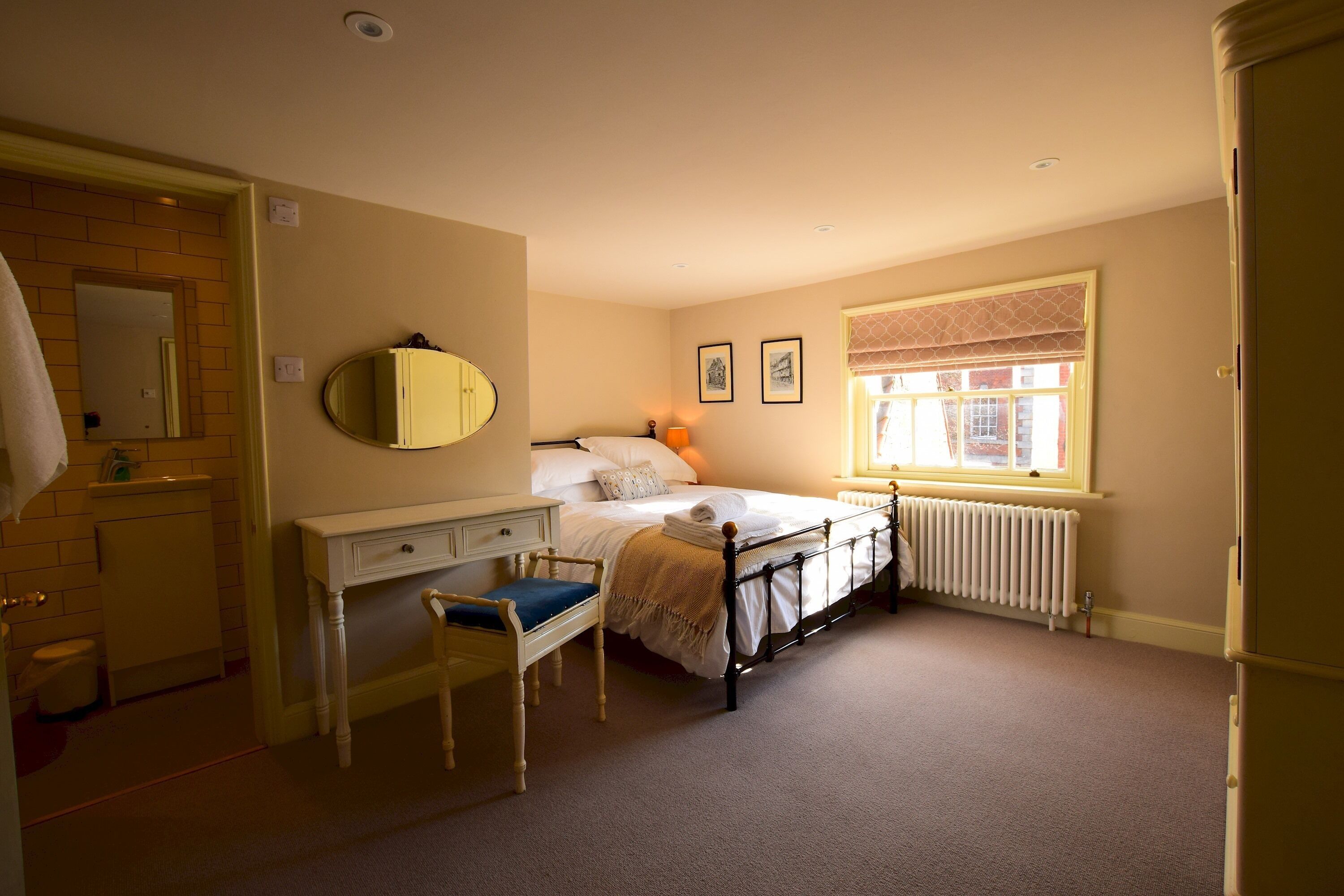 Une chambre à coucher comprenant un lit, une table de chevet, une chaise, une commode et une fenêtre donnant sur un paysage agréable.